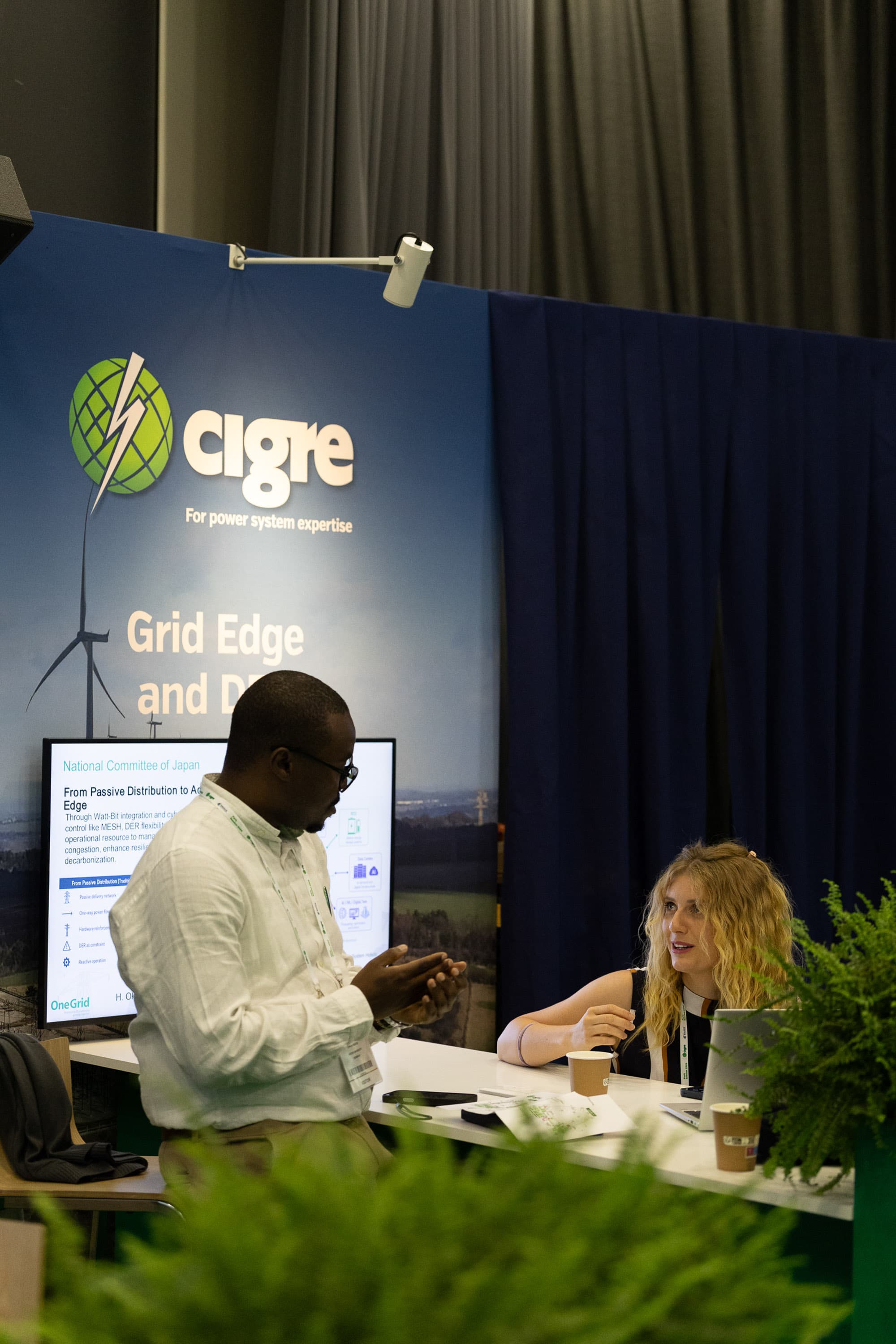 Clifford Ondieki in discussion at the CIGRE Grid Edge and DER node, OneGrid Pavilion
