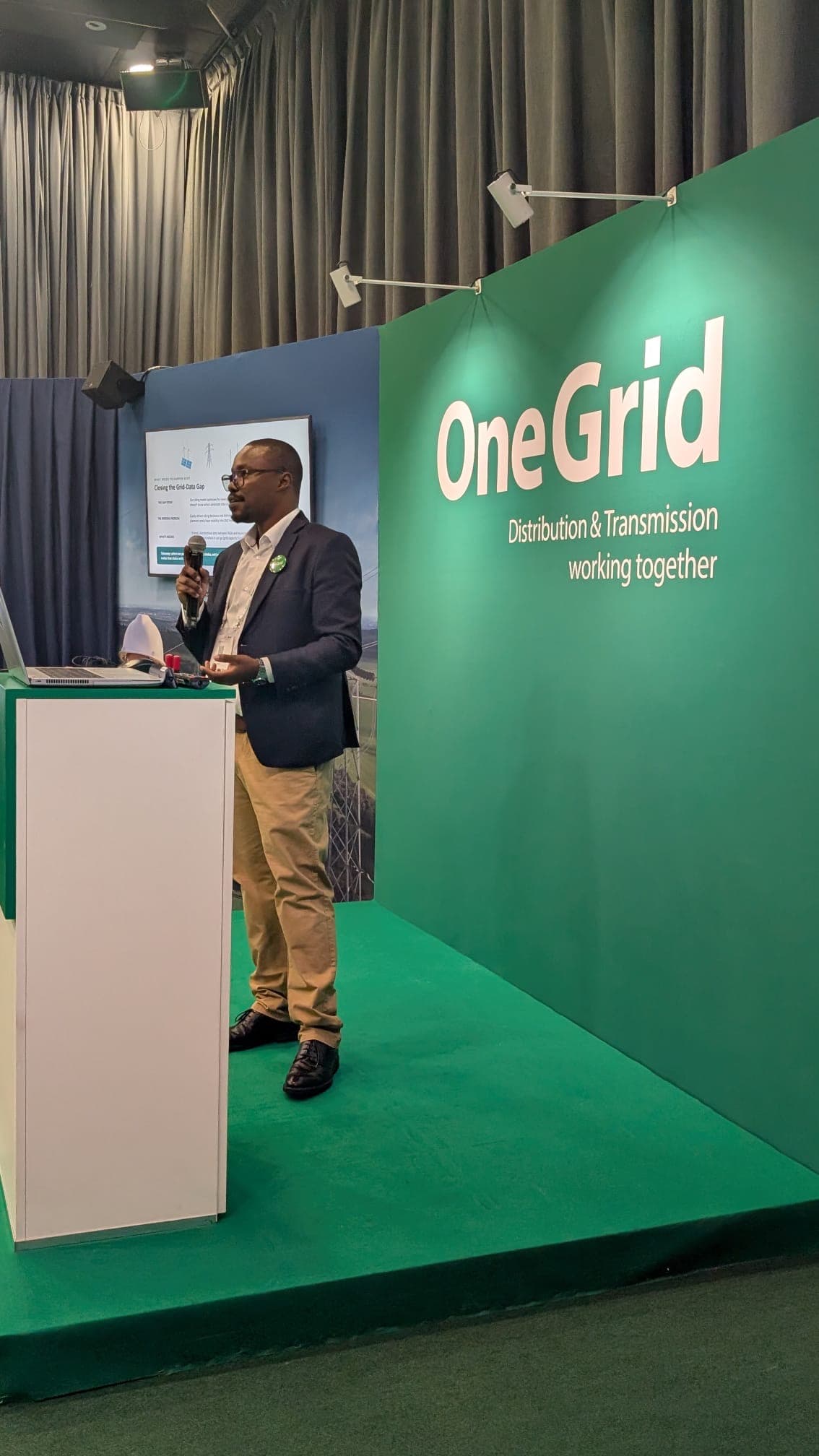Clifford Ondieki at the lectern, OneGrid Pavilion, CIGRE Session Paris 2026 — slide reads ‘Closing the Grid-Data Gap’